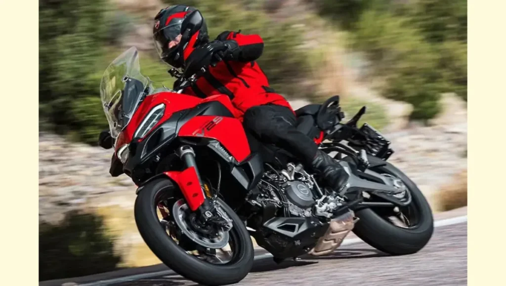 Rider cornering on 2025 Ducati Multistrada V2 in red during a mountain road test
