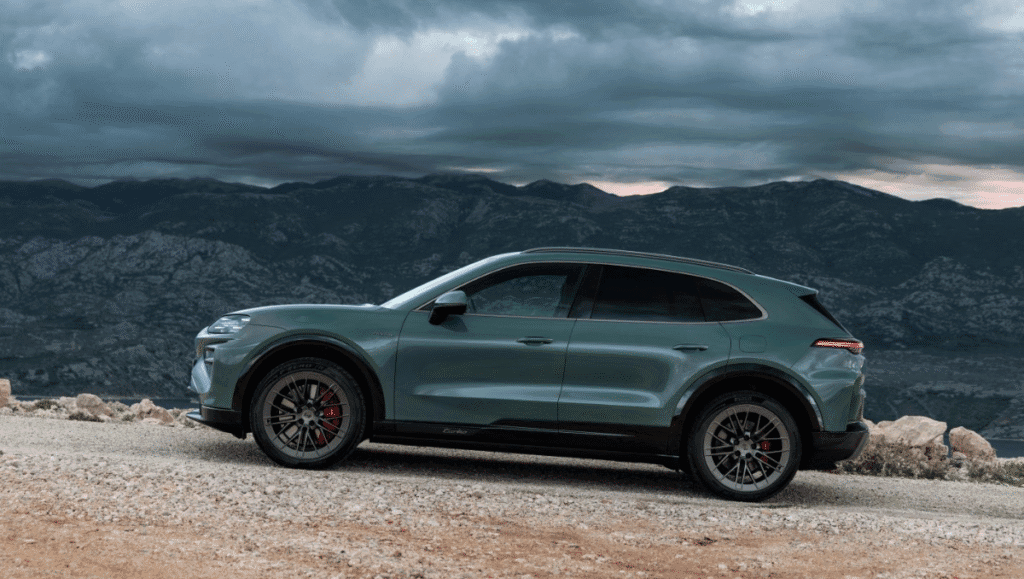 Side profile of Porsche Cayenne Electric Launched showcasing sleek electric SUV design on mountain road