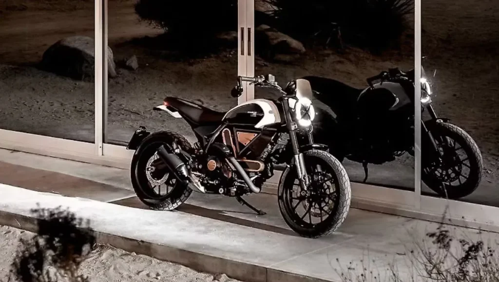 Ducati Scrambler 10° Anniversario Rizoma Edition parked at night showcasing its premium Metal Rose accents