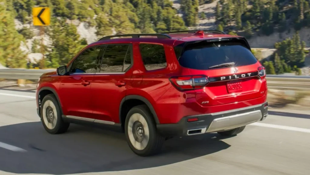 Red Honda Pilot driving on highway showing rear view of modern family SUV