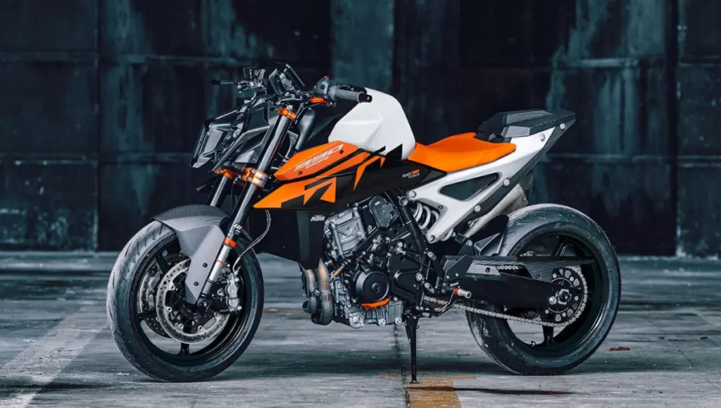 2026 KTM 990 Duke Breaks Cover with New Colors displayed in a raw industrial setting with updated orange and white design