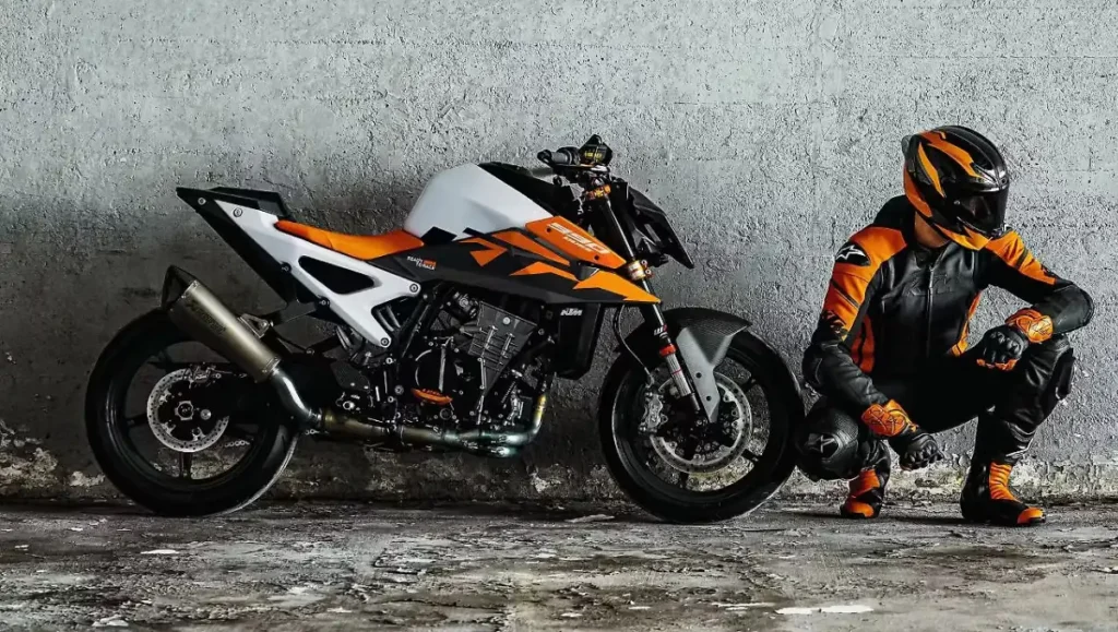 2026 KTM 990 Duke Breaks Cover with New Colors alongside rider in matching orange black gear