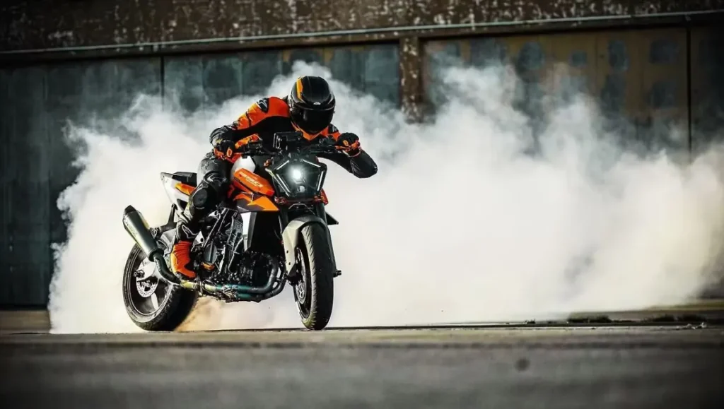 2026 KTM 990 Duke Breaks Cover with New Colors showcased during a burnout stunt on an open industrial ground