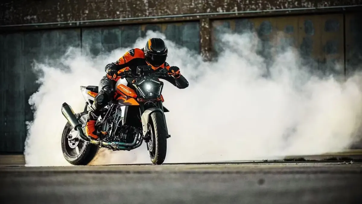 2026 KTM 990 Duke Breaks Cover with New Colors showcased during a burnout stunt on an open industrial ground