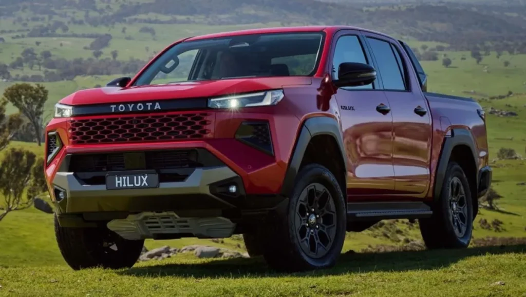New Toyota Hilux Debuts 2026 in red – next-generation pickup truck on rugged terrain