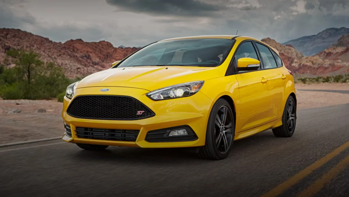Yellow Ford Focus ST on an open road, illustrating the story of Ford Focus production ends after 27 Years