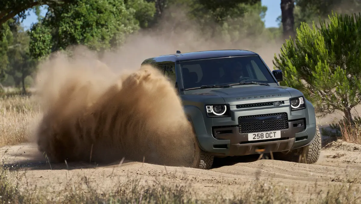 JLR India opens Defender Journeys 2026 booking showcased through Land Rover Defender driving through sand during off road adventure