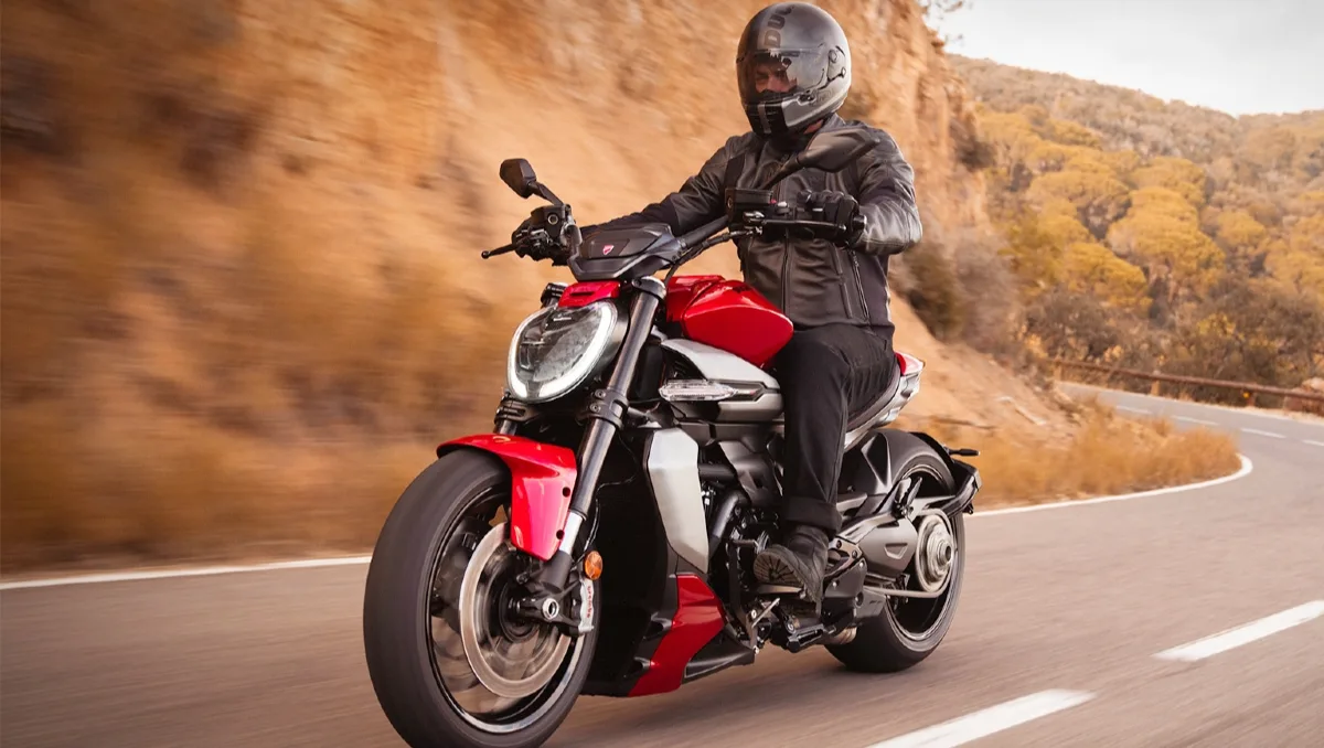 Ducati XDiavel V4 Launched in India seen in motion on a winding road, showcasing its muscular cruiser stance and bold design