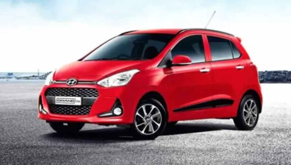 Red Hyundai Grand i10 hatchback parked outdoors showing front side profile