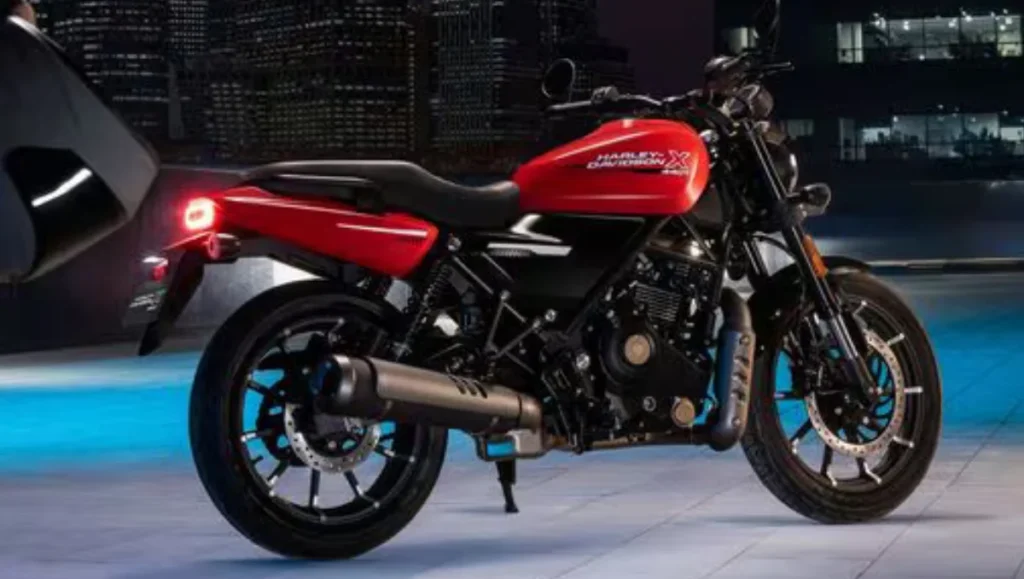 Harley Davidson X440 T motorcycle shown in red colour with rear three quarter view under city night lighting