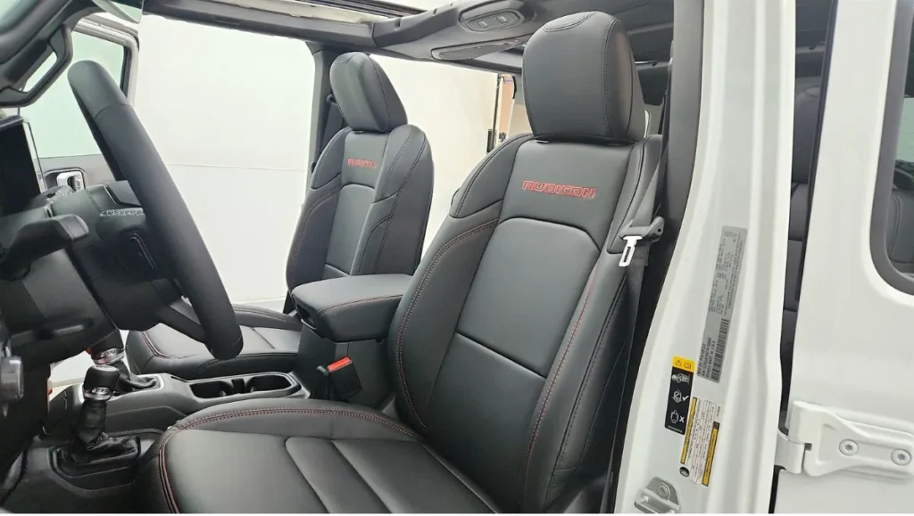 Interior view of the 2026 Jeep Wrangler Whitecap showing front seats with Rubicon branding and durable cabin materials