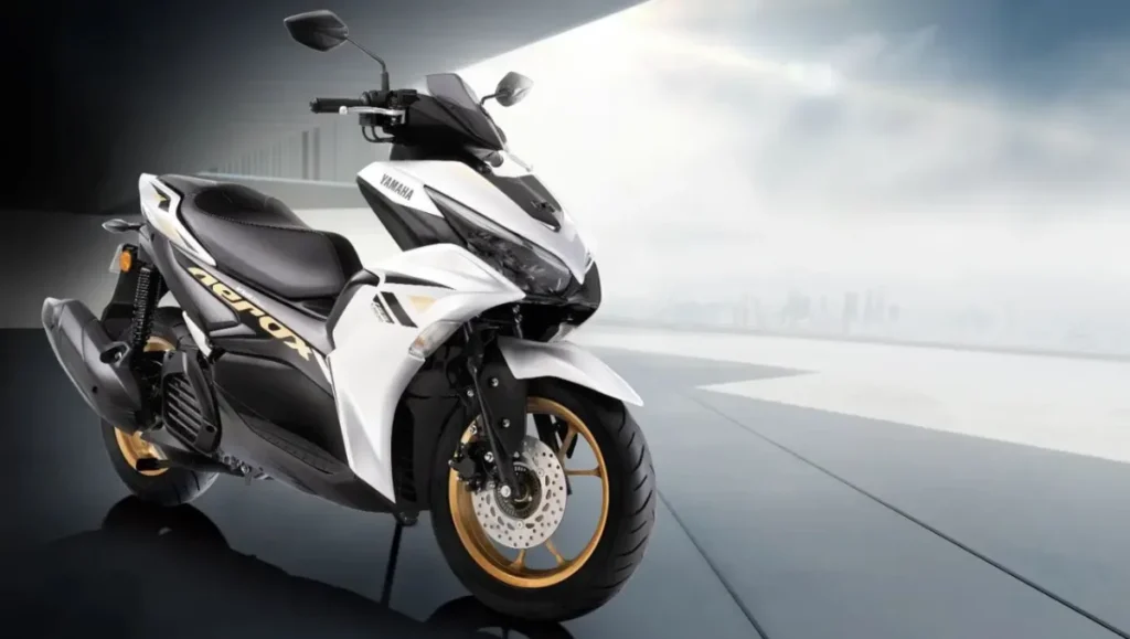 White Yamaha Aerox 155 scooter with gold alloy wheels showcasing sporty design and premium road presence