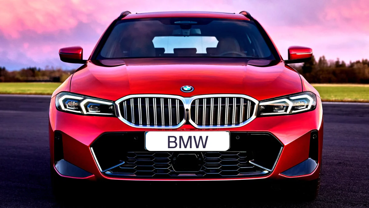 BMW Fire Recall red BMW sedan front view with illuminated LED headlights parked on open road at sunset