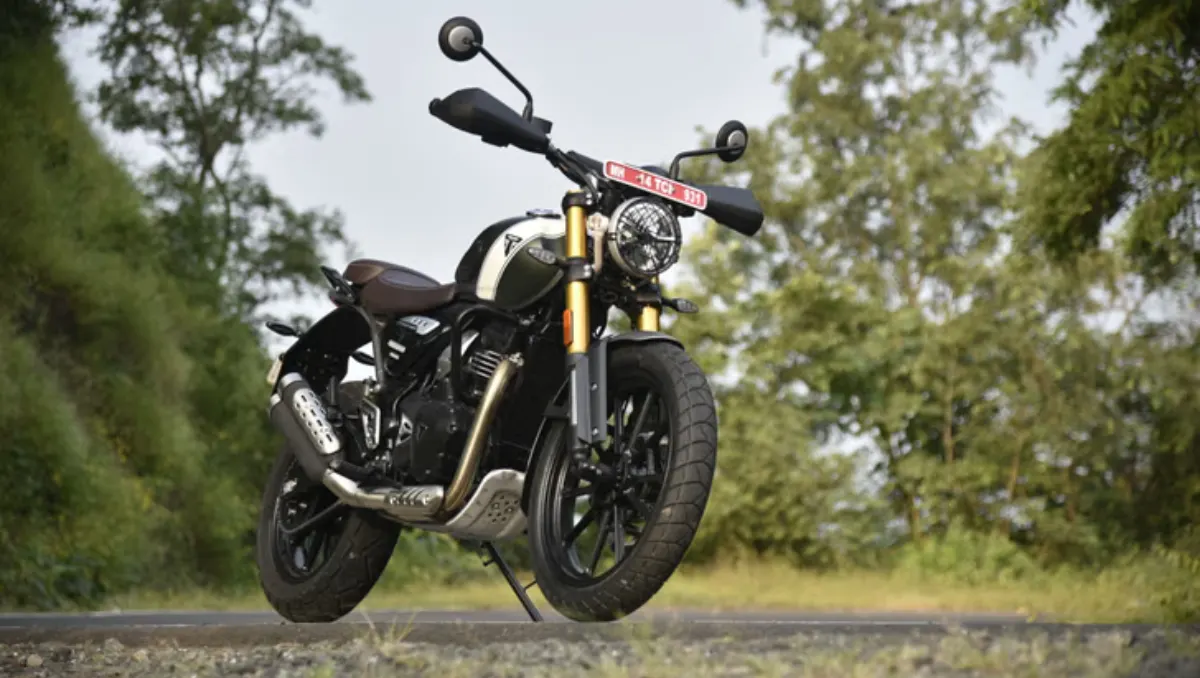 Triumph’s New 350cc Range scrambler-style motorcycle parked on a scenic roadside with golden front forks and retro design