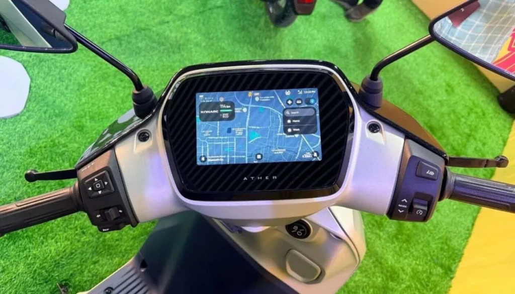 The futuristic digital dashboard of the Ather Konarc electric scooter displaying a full-screen navigation map and "KONARC" vehicle status.