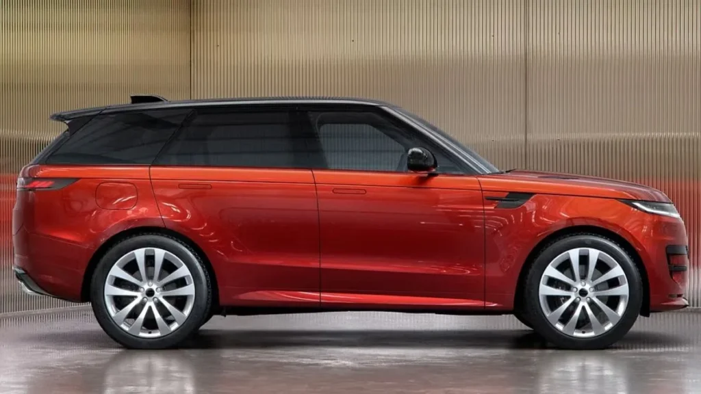 Side view of the Range Rover Sport Twenty Edition showcasing its Sanguinello Orange paint, 23-inch alloy wheels, and flush door handles.
