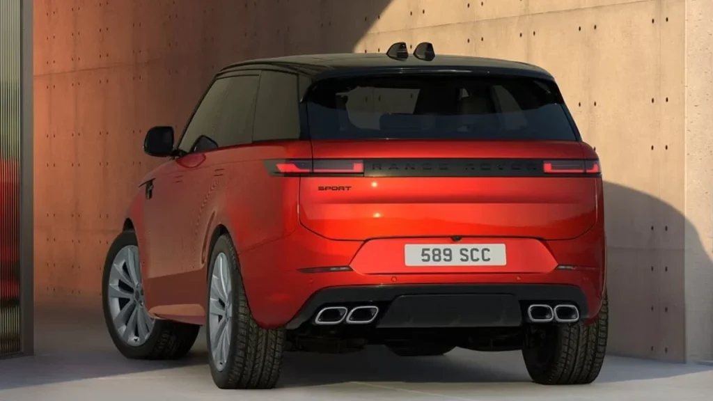 Rear profile view of the Range Rover Sport Twenty Edition in ultra-metallic Sanguinello Orange with quad exhaust pipes and black roof contrast.