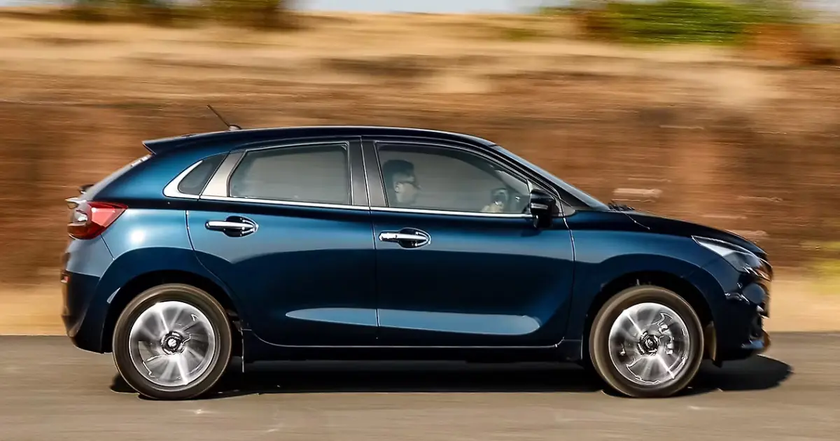 Front three-quarter angle of the Maruti Suzuki Baleno premium hatchback showcasing redesigned front grille, LED headlights, and sharp bumper detailing.